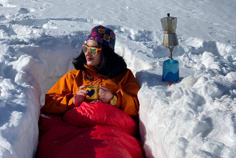 Personne dans un abri de neige avec duvet rouge
